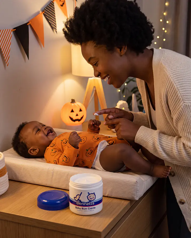 A mom putting Bennetts Baby Bum Crème on her baby at the changing mat