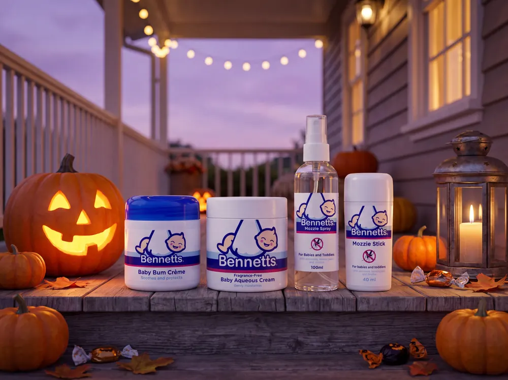 Bennetts Baby Bum Crème, Aqueous Cream, Mozzie Spray and Mozzie Stick on a porch at dusk beside a lantern